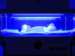 نوزاد خوابیده زیر نور آبی دستگاه زردی نوزاد برای درمان بیماری زردی